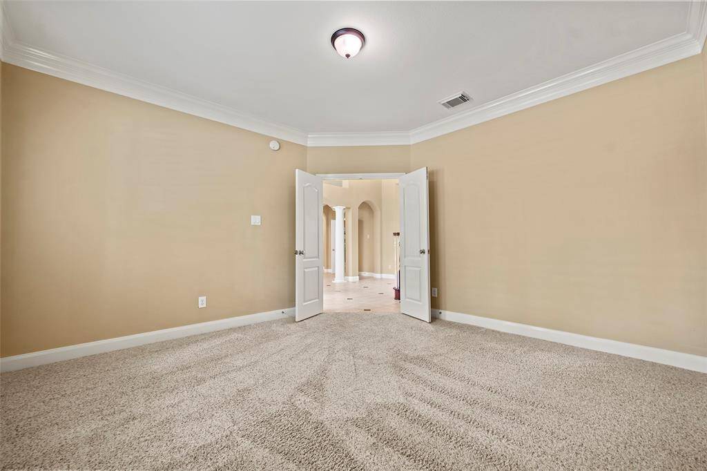 This spacious room  opens into a bright hallway with arched entryways, creating a warm and inviting atmosphere.