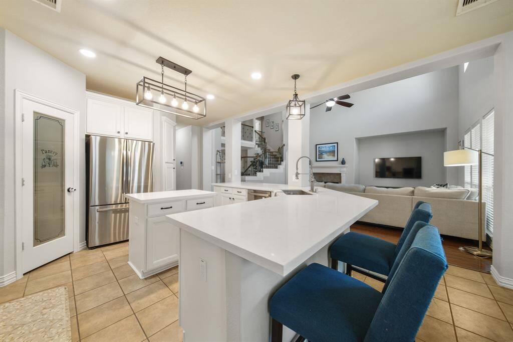 The GE stainless steel appliance package includes a 4-burner gas cook top (2024) & built-in microwave oven with ventilation & lighting above (2022), double built-in conventional ovens and a dishwasher. A tankless water heating system was installed in 2022 and the existing French door refrigerator/freezer (2022) stays with the home. This kitchen includes an abundance of counter space, cabinets & soft-close drawer storage, built-in & walk-in pantries and a wine storage rack.
