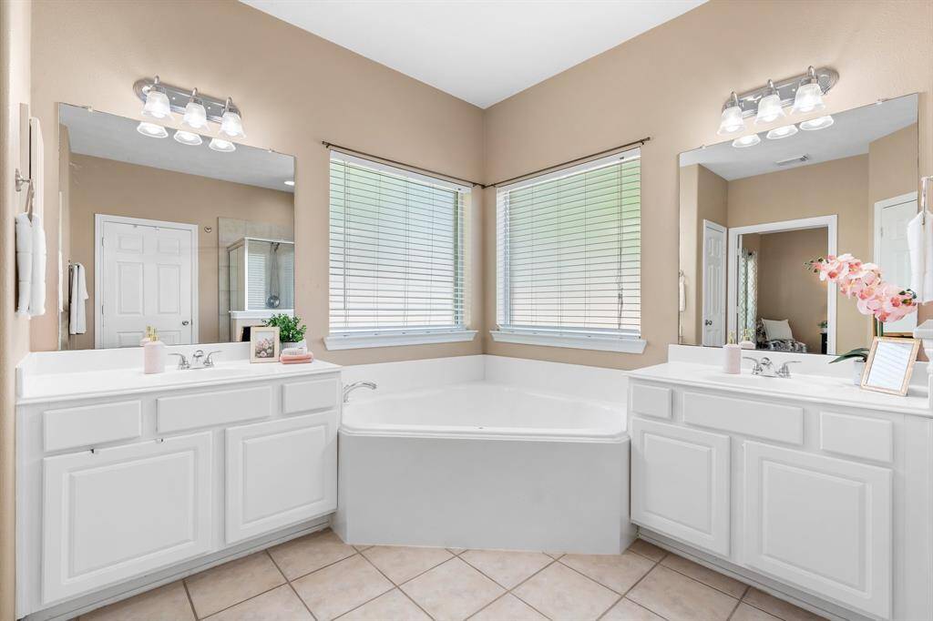 Primary bath with jetted tub, double vanities, and separate shower.