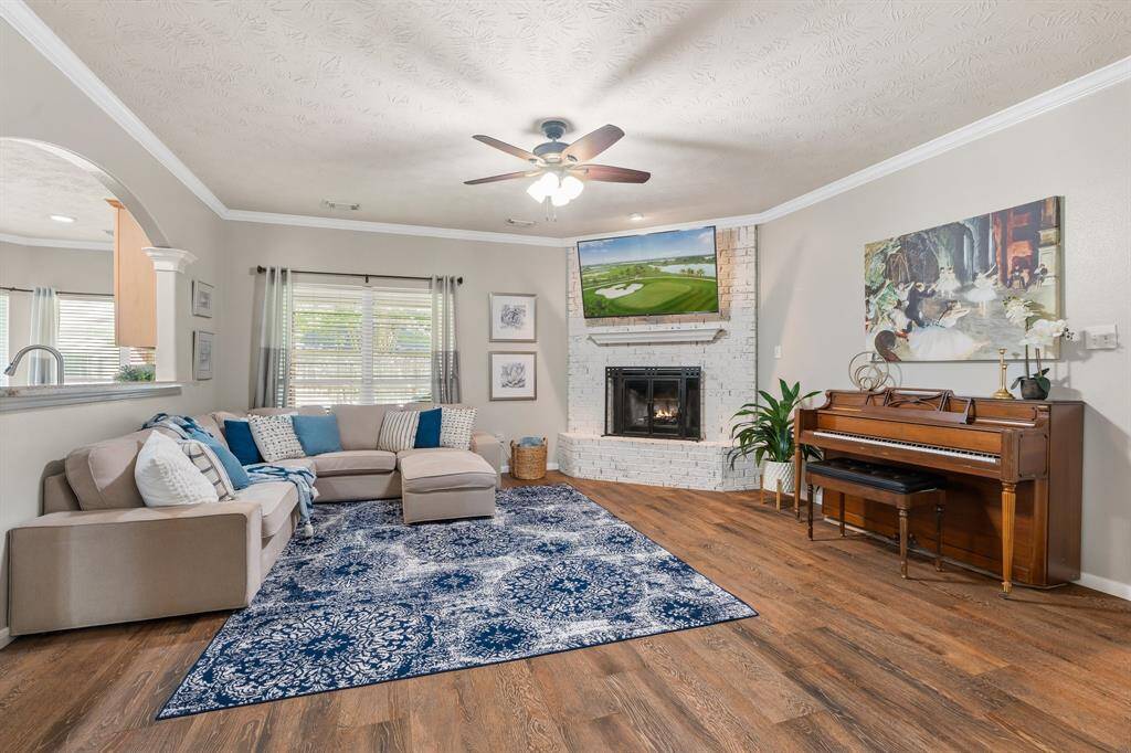 Living room with lovely brick, wood burning fireplace.