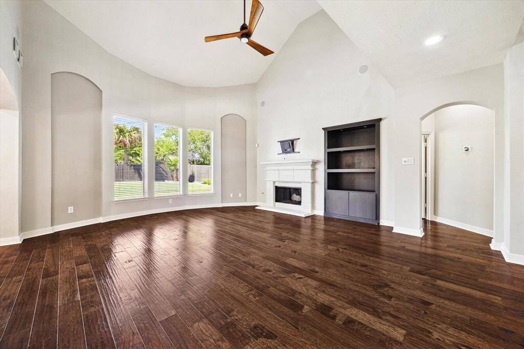 Family room with well appointed cast-stone gas fireplace & custom celling fan