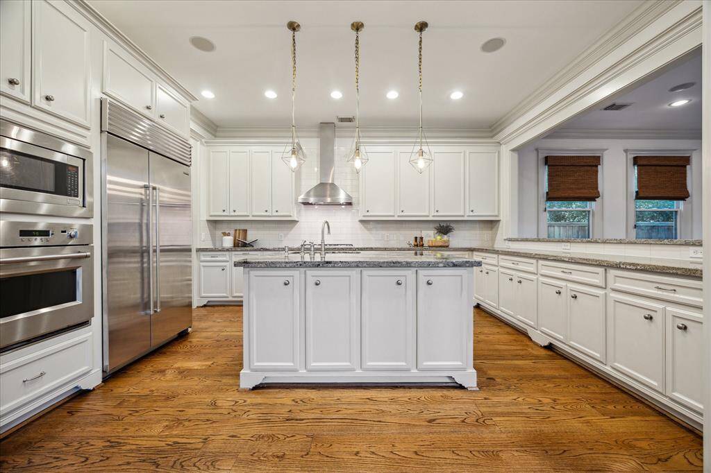 The sprawling gourmet kitchen is a chef’s dream surrounded by rows of full-feature custom cabinetry, granite countertops, subway tile backsplashes and under-cabinet lighting.