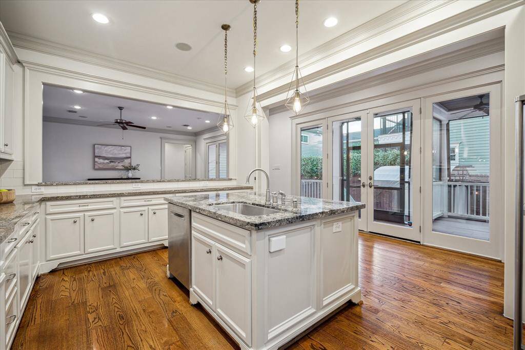 A massive center island topped by handsome pendant lighting adds prep space and a large undermount stainless steel sink.