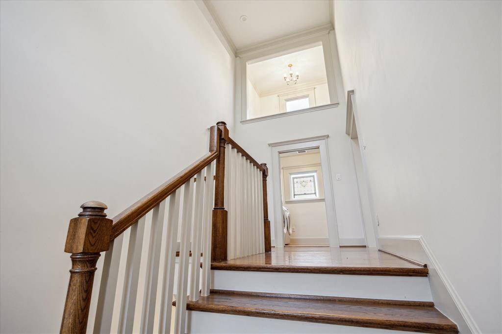 Handsome rear stairs lead to the home’s bright and airy double-height upper level.