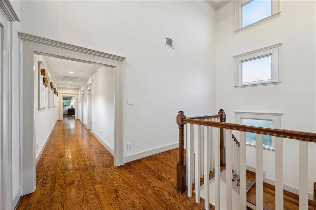 A large landing and wide hallway lead to the home’s additional bedrooms, including the primary suite.