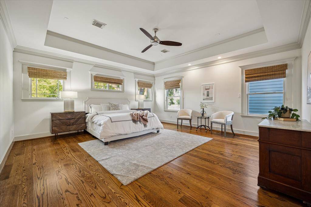 Sleep soundly in this spacious primary suite topped by a tall tray ceiling and fan.