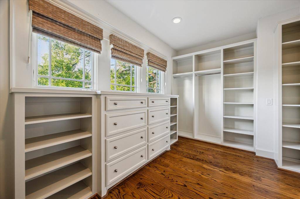 Discover wonderful wardrobe storage in the fully customized, windowed walk-in closet featuring built-in dressers, shoe shelves and double hanging rods.