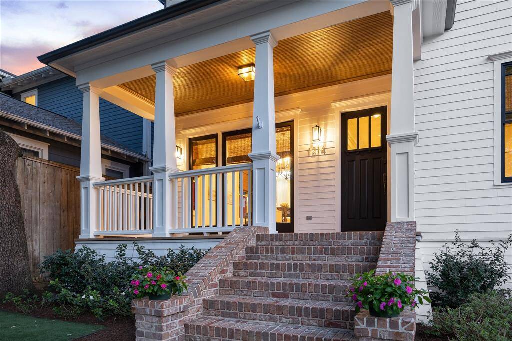 Brick steps and a beautiful white façade with upscale windows add stately elegance to this two-story Houston Heights home.