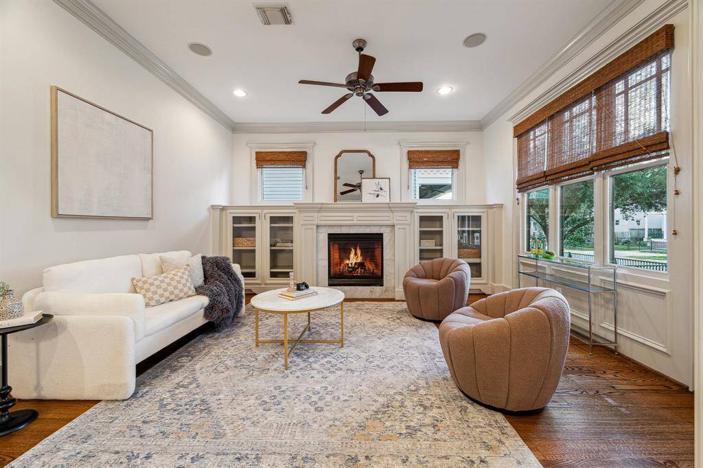 – To the right of the entry, the formal living room invites you to relax and unwind alongside a gas log fireplace flanked by custom built-in cabinetry. Windows throughout the home boast custom blinds.