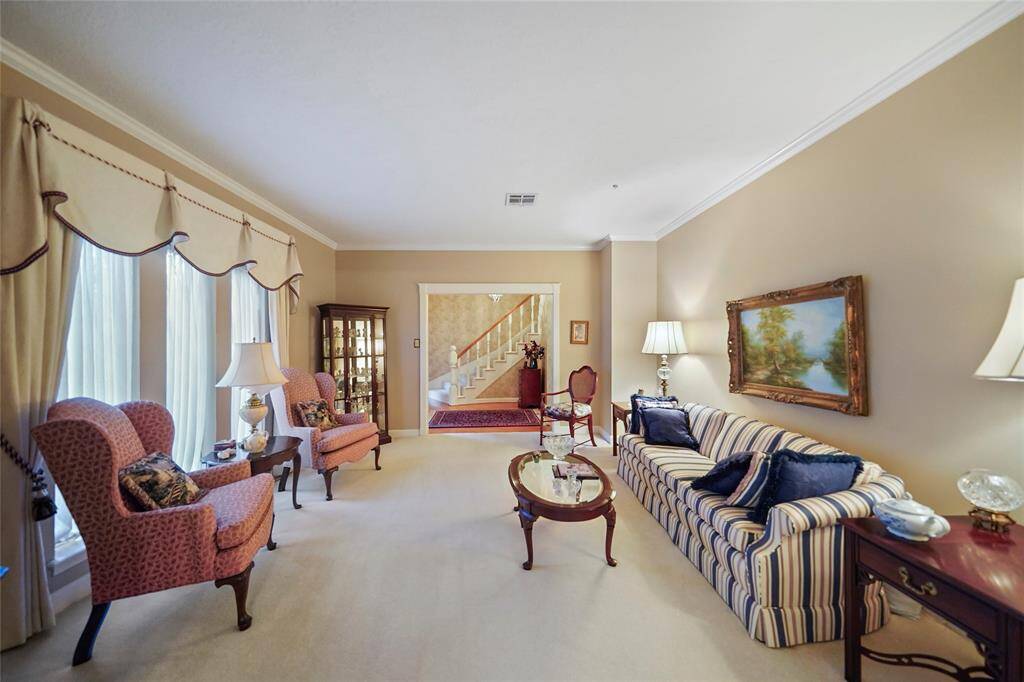 Elegant living room with a classic design. It is a well-lit room which features large windows to front of the home.
