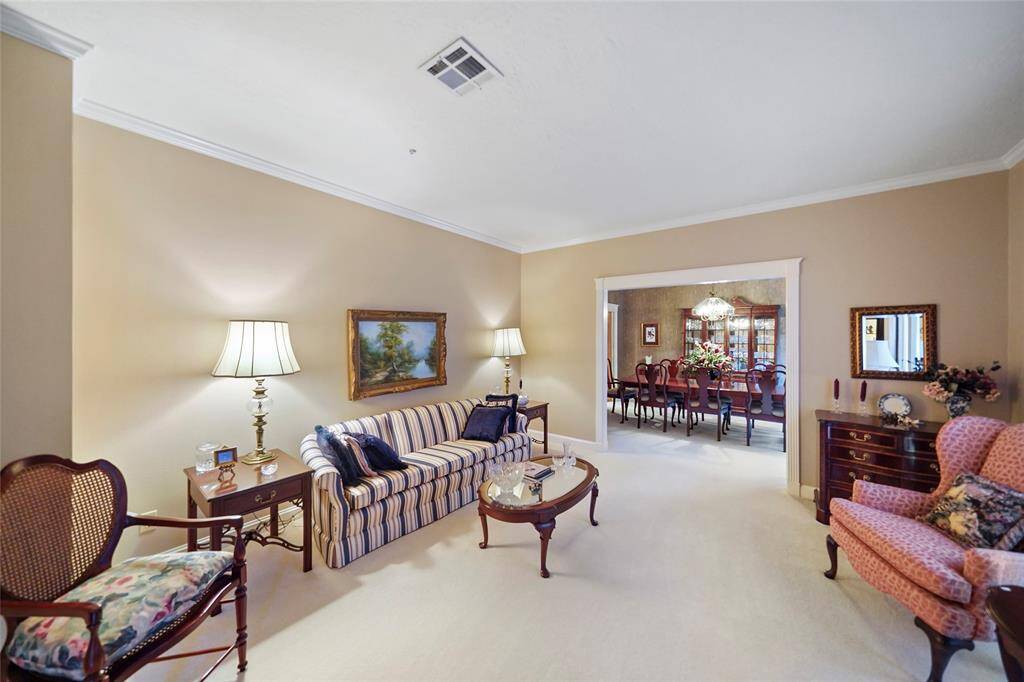 This inviting living room features warm, neutral walls creating a cozy atmosphere. The room opens to a formal dining area, enhancing the space's open feel.