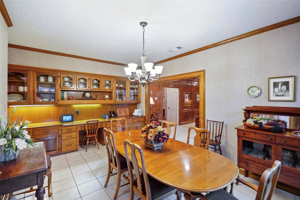 Breakfast room features a custom built-in wooden cabinetry with ample storage, and decorative lighting. The space is warm and inviting, perfect for family gatherings.