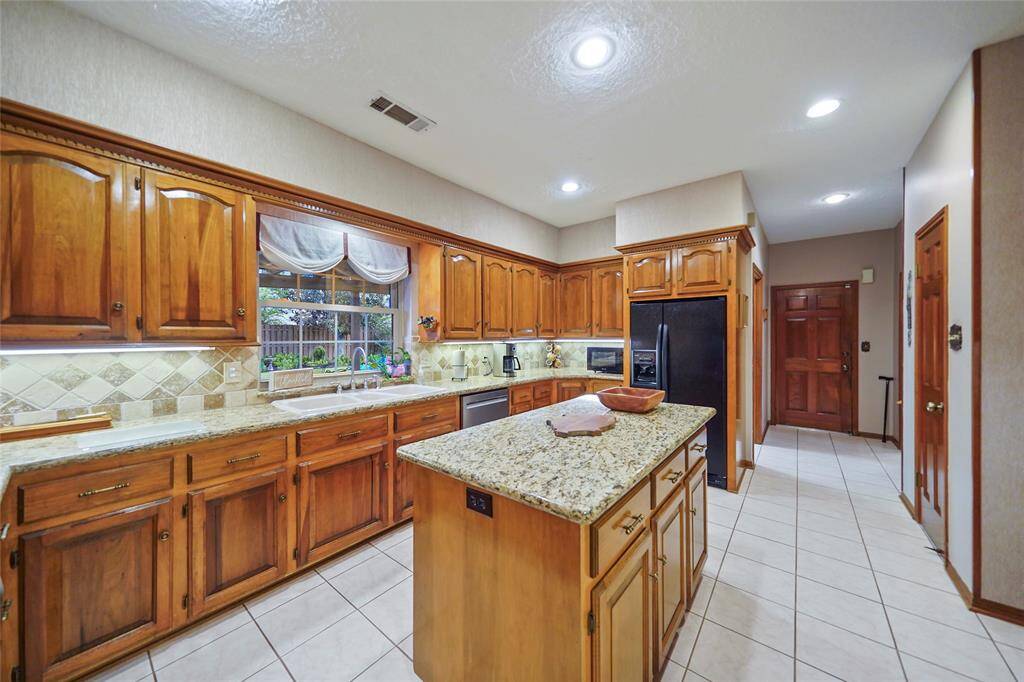 This spacious kitchen affords welcoming and functional cooking space.