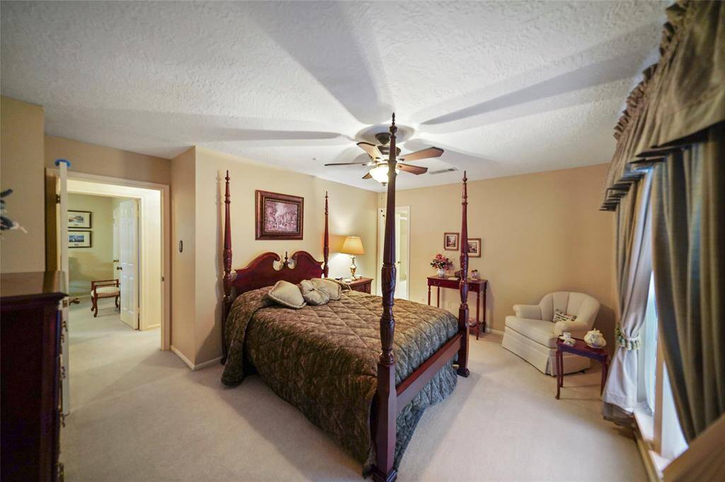 This cozy guest bedroom features large windows creating a warm and inviting atmosphere.