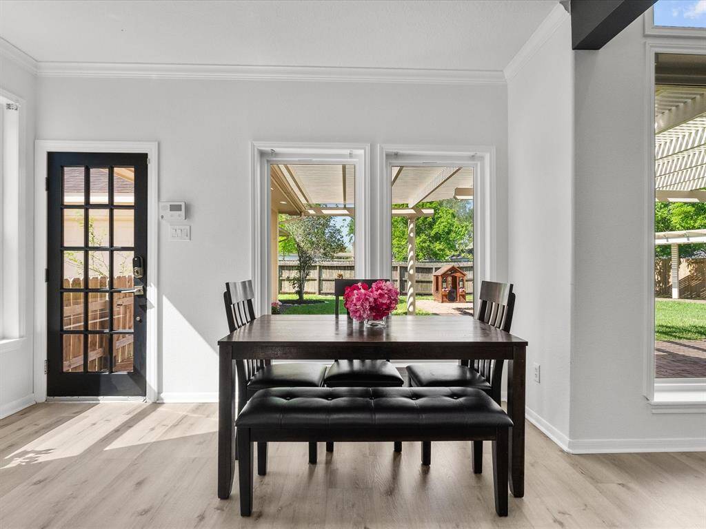 Bright breakfst area with large windows, offering a view of a lush backyard. Perfect for enjoying meals and natural light.