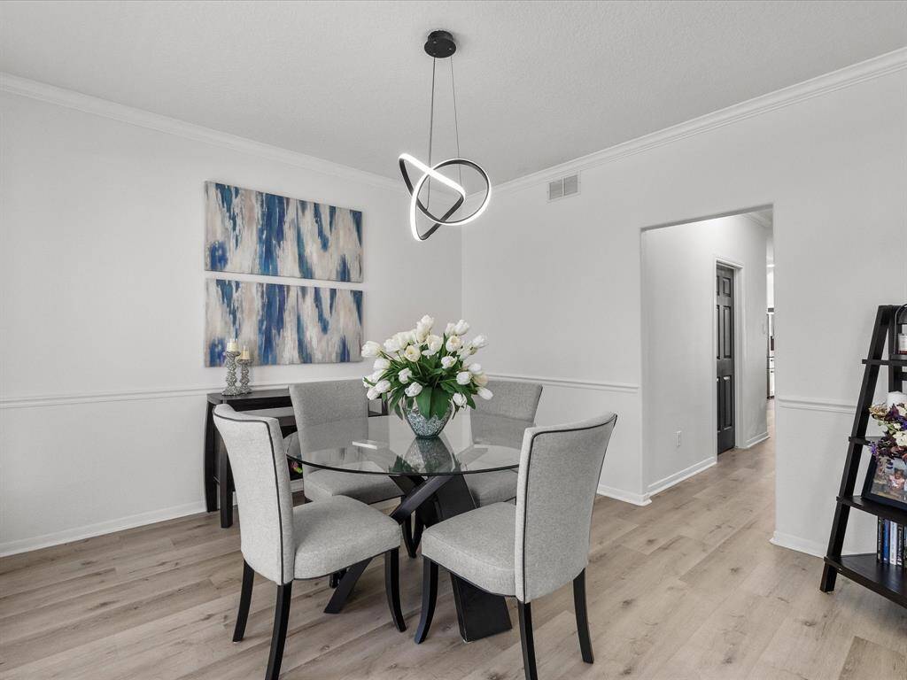 Elegant dining area with a modern light fixture to compliment the rest of the home.