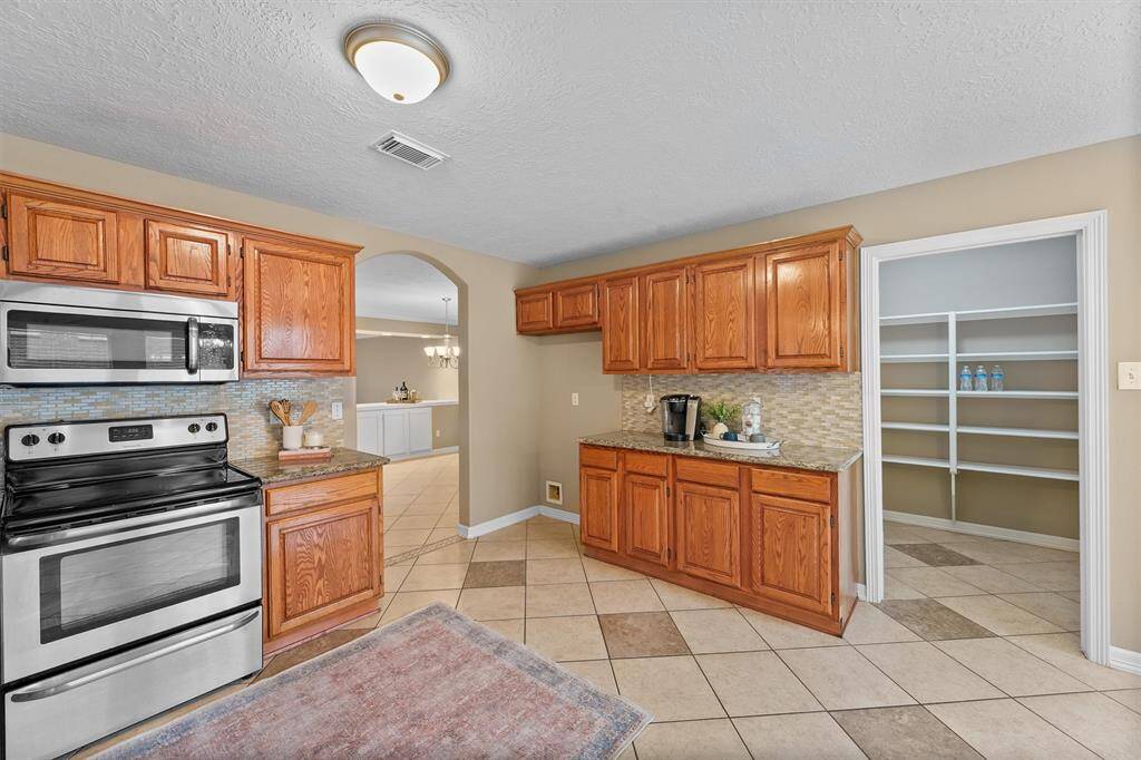 Granite countertops, electric range and microwave. There's plenty of space to add a beautiful and functional island piece.