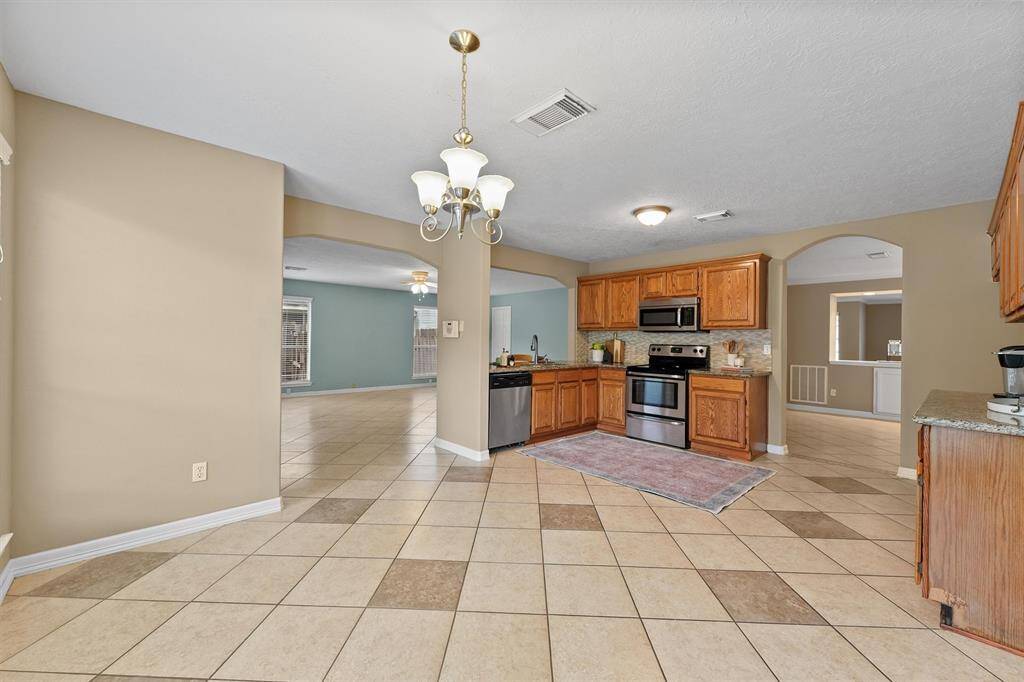 View from breakfast room into the kitchen, family room and dining room