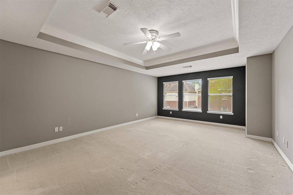 The Texas-sized primary bedroom overlooks the backyard and so pretty with the tray ceiling. You'll love retreating here at the end of the day and waking up here in the morning.