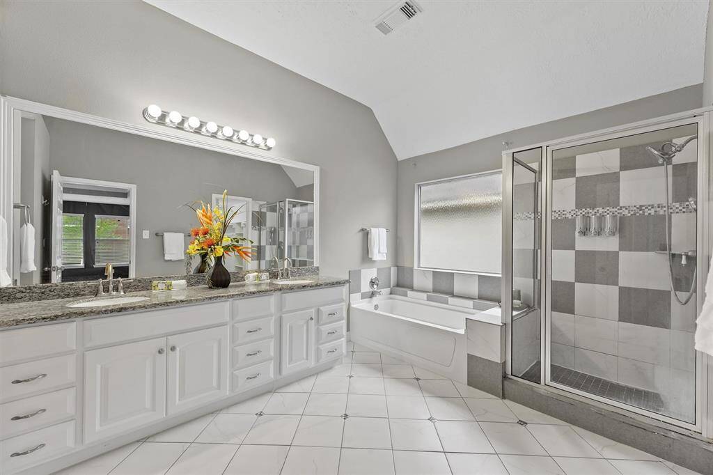 Plenty of storage in this primary bathroom. Separate tub and shower with glass doors. There's a linen closet and water closet here, too.