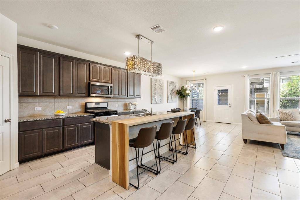 A chef’s dream come true with eat in island & butcher board island extension, stainless steel appliances & granite countertops.