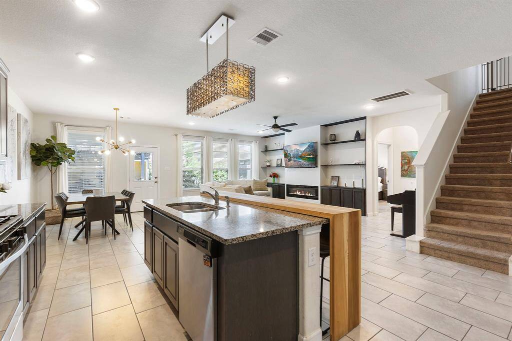 Another view of the kitchen overlooking the beautiful, light and bright living area. Notice the beautiful, upgraded lighting fixture above the island.