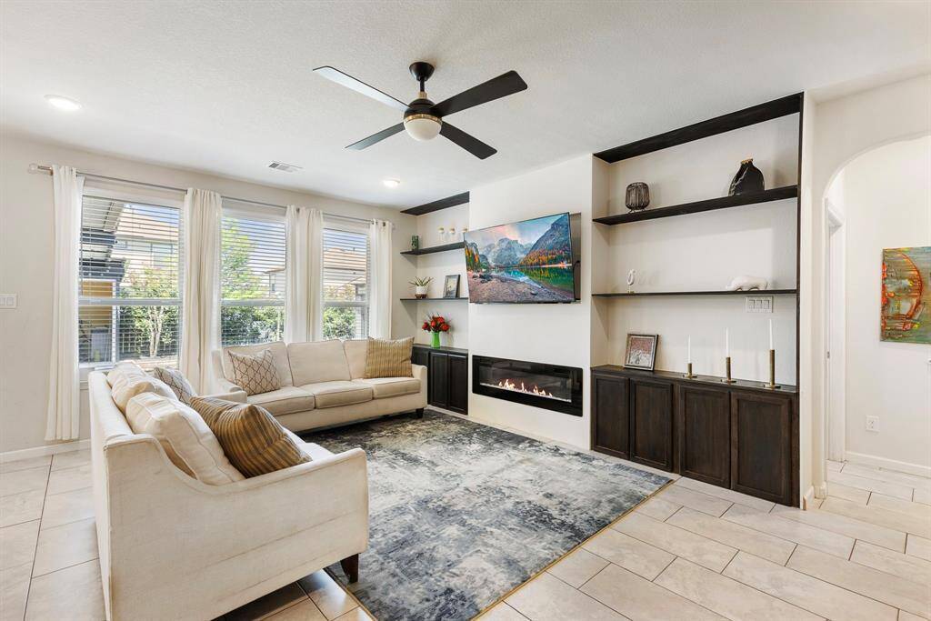 This gorgeous living room features modern finishes, custom built-in shelving, and a sleek fireplace.