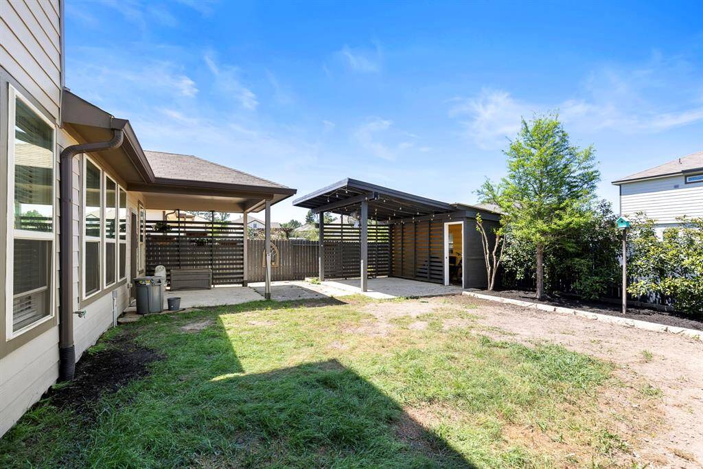 This generously sized backyard has plenty of room for activities as well as an extra covered patio & storage area. Notice all the lush landscaping throughout the backyard.