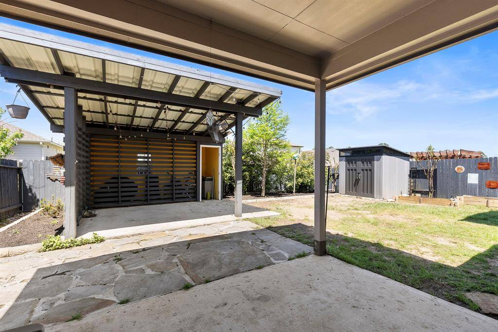 Enjoy this covered back patio extension with additional storage and an outdoor fan to cool off on a hot Texas day.