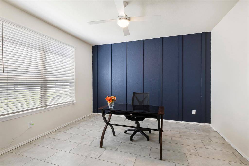 The home office features a handsome accent wall & French doors.