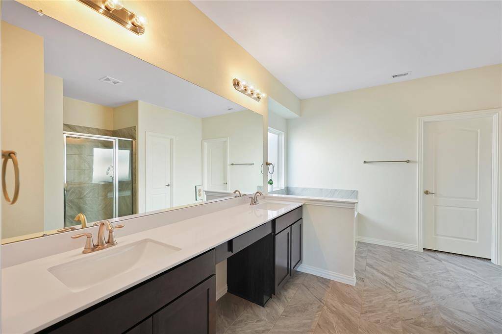 The primary bathroom features double sinks, a separate soaking tub, a spacious shower, a private toilet room, and direct access to the expansive primary closet.