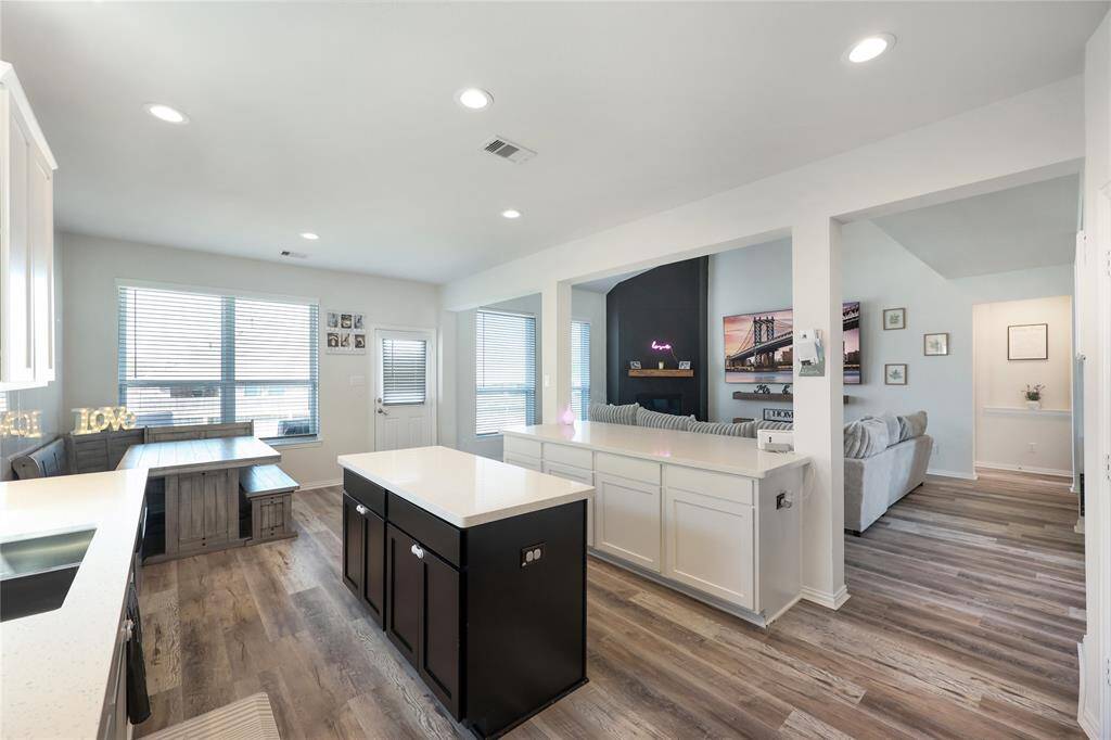 Open-concept design seamlessly connects the living room, kitchen, and breakfast area to the backyard for effortless indoor-outdoor living.