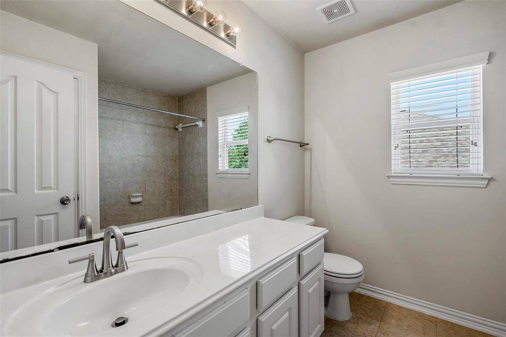 This inviting secondary bathroom boasts a convenient bathtub and shower combo for ultimate versatility.