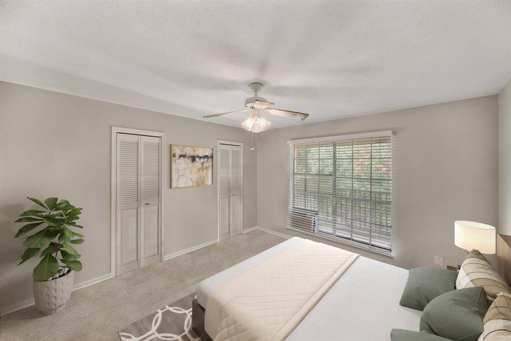 Virtually Staged: A great place to rest after a long day! This magnificent primary bedroom features carpet floors, a ceiling fan, walk-in closets and large windows with privacy blinds.