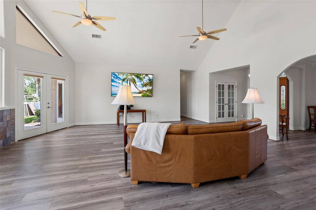 Spacious living room with high ceilings, abundant natural light, and indoor-outdoor sound system.