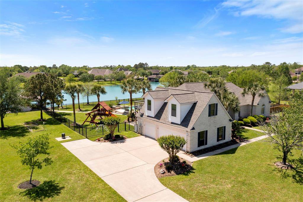 This custom built 1.5-story home features a spacious driveway, 3-car oversized garage, a well-maintained yard, and a fenced backyard with a pool, hot tub, playset and private boat dock.