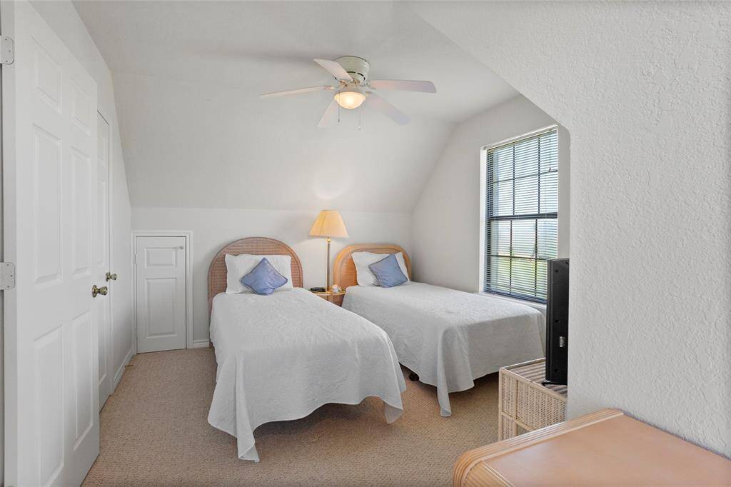 Bright upstairs bedroom with large windows and generous closet space.