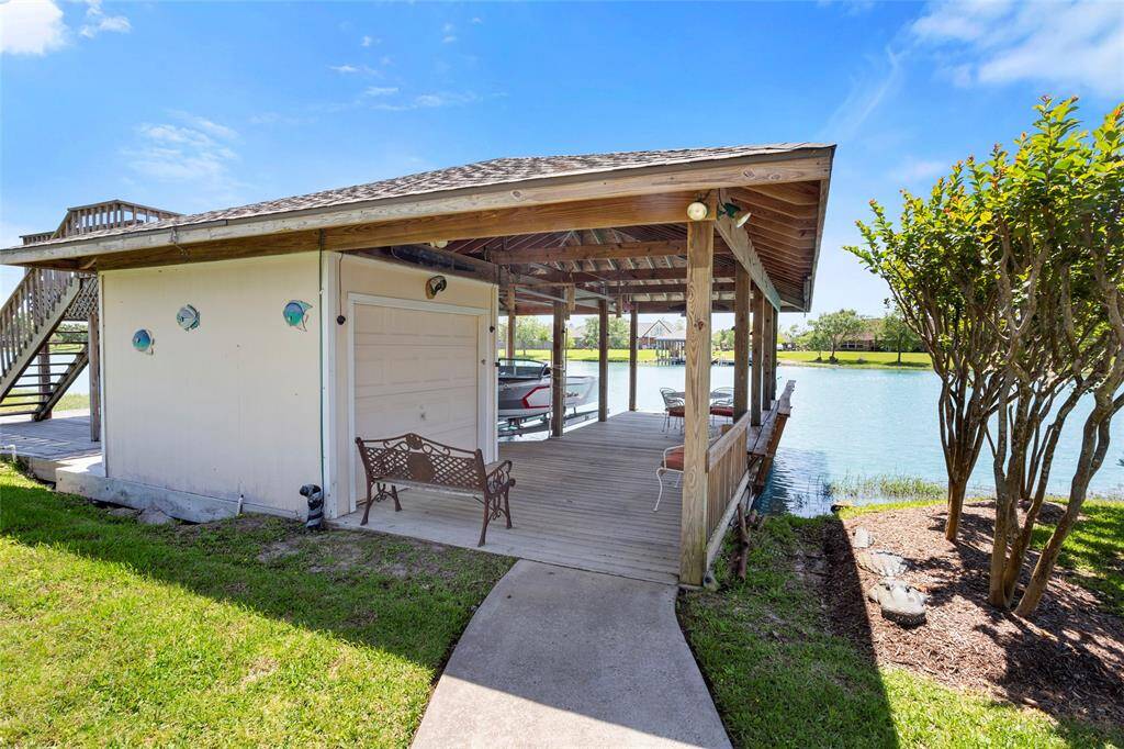 Experience serenity at this lakeside retreat with a rustic dock and cozy seating. Enjoy stunning water views from the deck, surrounded by lush greenery—perfect for relaxing by the water.