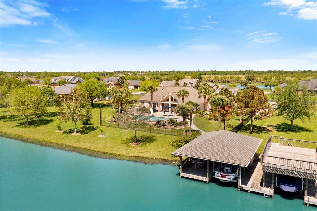 Discover luxury in this stunning waterfront home, featuring modern design and lush greenery. Enjoy a private dock and serene waters ideal for boating and outdoor activities. Situated in a peaceful, well-kept, gated neighborhood.