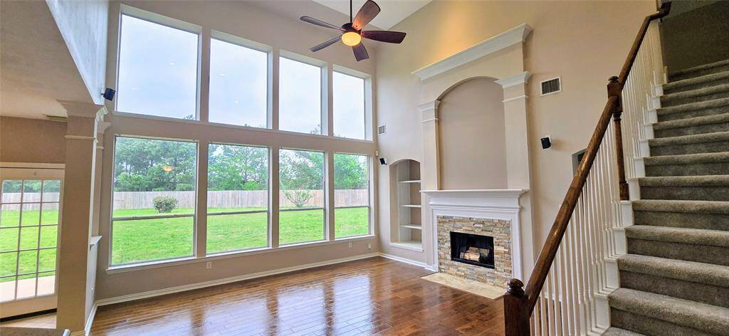 Soaring windows fill the living room with abundant natural light, creating a bright and open feel