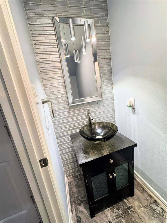 Elegant powder room featuring modern fixtures, sleek cabinetry, and a stylish design for a sophisticated touch