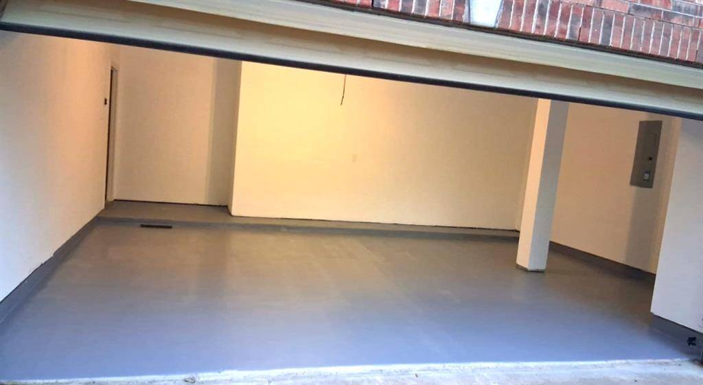 Spacious two-car garage featuring a newly painted epoxy floor—durable, easy to maintain, and perfect for storage, hobbies, or a polished workshop setup