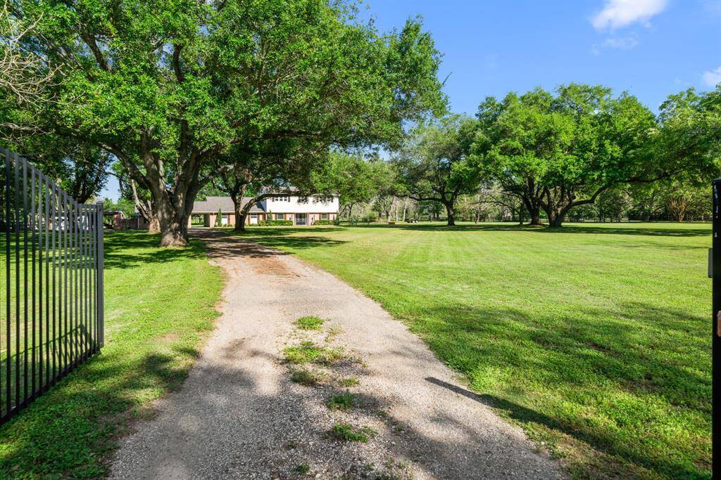 Left side gated entrance into the property. This lead directly to attached garage and extra parking to the right, the carport (2) vehicle capacity and the front of the home.