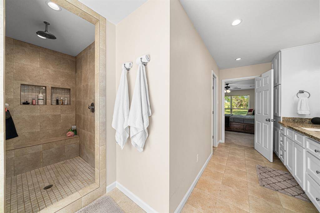 Walk in shower is all tile with a seating area.