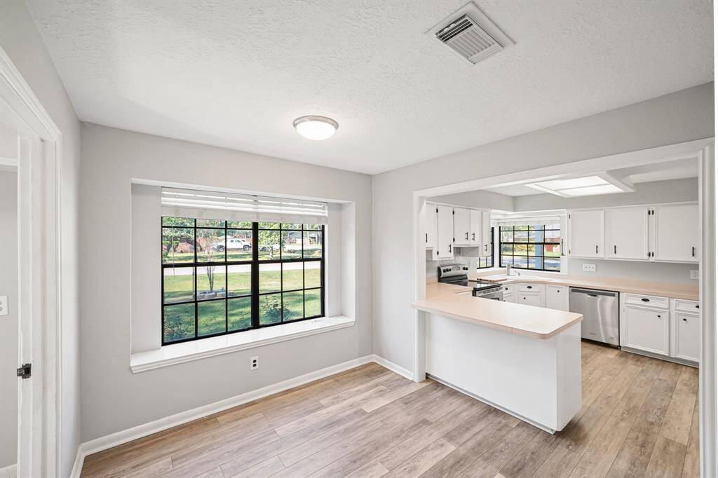 Charming breakfast area just off the kitchen, complete with tile floors, and a large window.