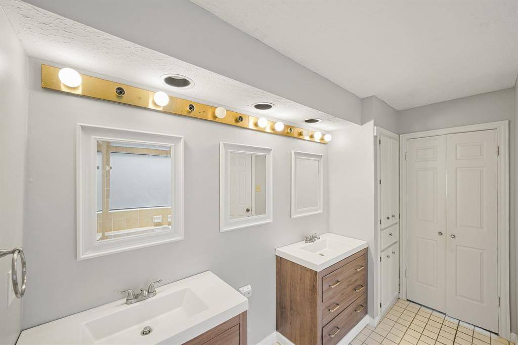 It features double sinks with granite countertops, and framed mirrors.