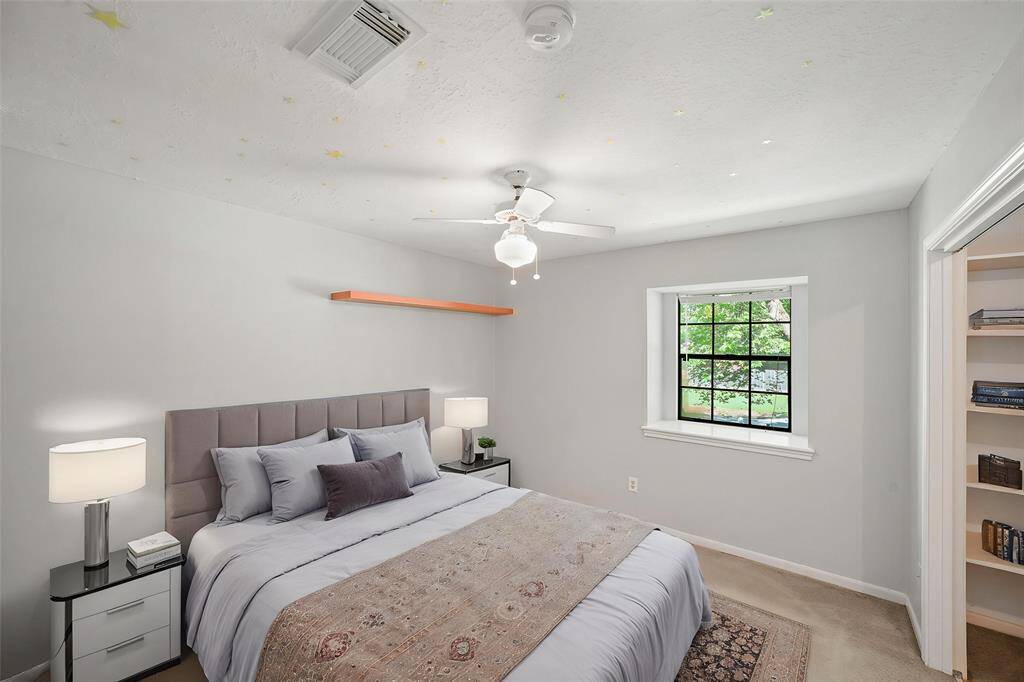 Virtually Staged: Secondary bedroom with carpet floors, a window, and a ceiling fan.
