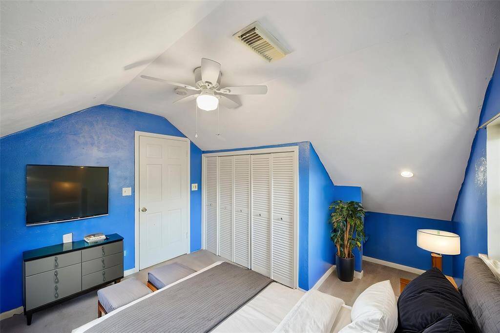 Virtually Staged: Secondary bedroom with a vaulted ceiling, a ceiling fan, and a built-in closet.