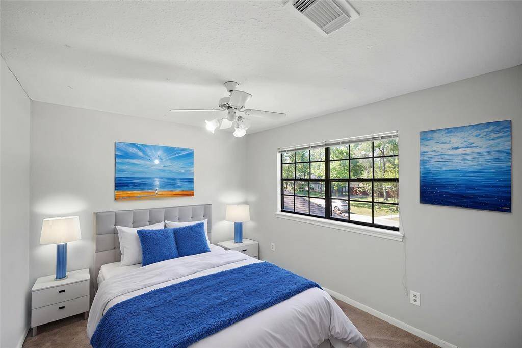 Virtually Staged: Secondary bedroom with carpet floors, a ceiling fan, and a large window.