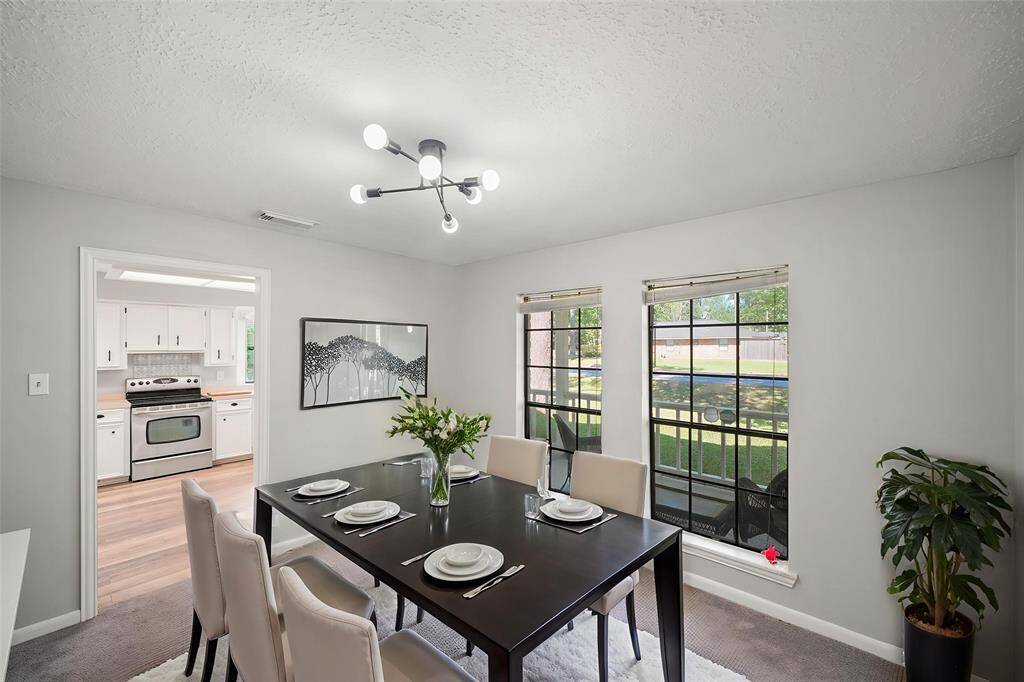 Virtually Staged: This space can become a perfect dining room. It has carpet floors, large windows, and immediate access to the kitchen.